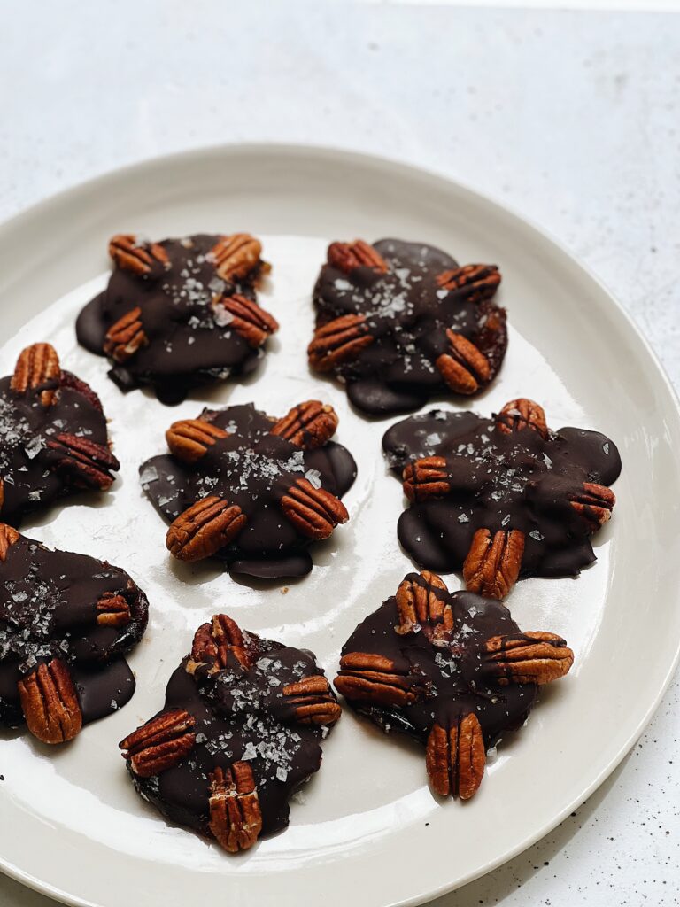 Plate of candy dates covered in chocolate and pecans