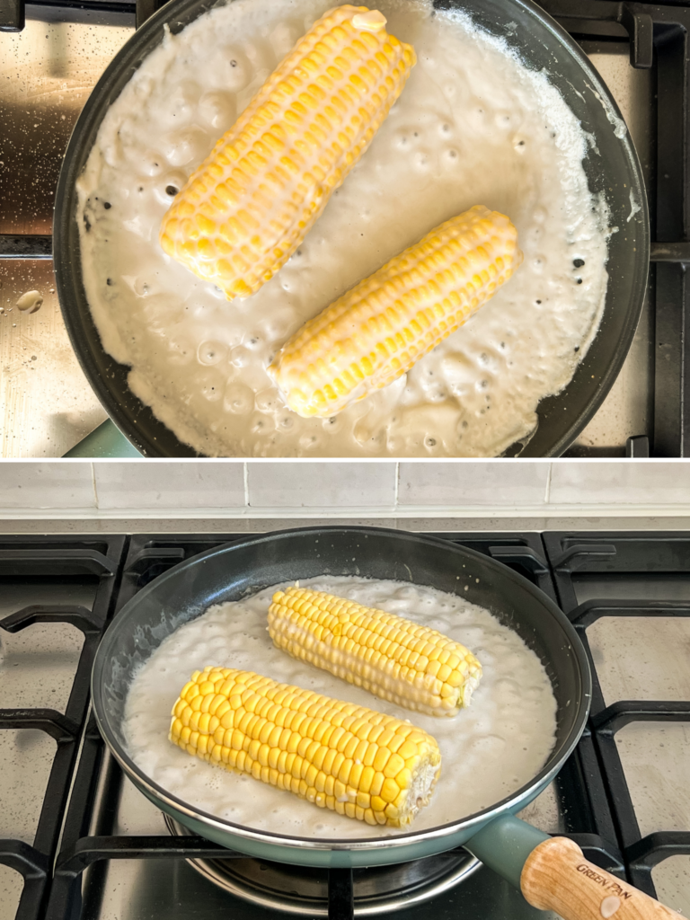 Two corns on the cob cooking in a pan of coconut milk